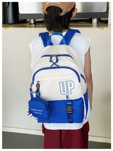 Detail view of large capacity white and blue color block backpack with UP logo
