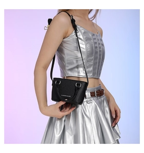 Detail of black litchi texture mini bag with silver Fashion & Bags lettering and metal ring