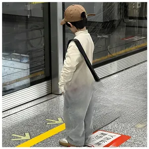 Détail du sac bandoulière bleu pour enfants avec lettrage blanc TOCHASO et sangle noire