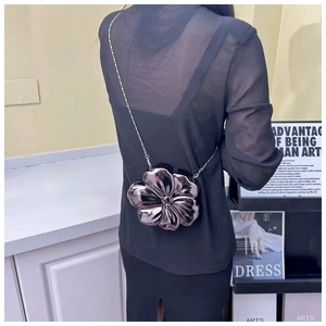 Detailed back view of a silver flower-shaped crossbody bag with a metallic chain strap