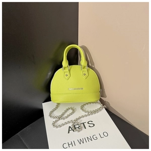 Detail of neon green shell handbag with pebble leather texture and silver chain strap