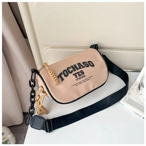 Detail view of beige canvas crossbody bag with black letter print and chain strap decor