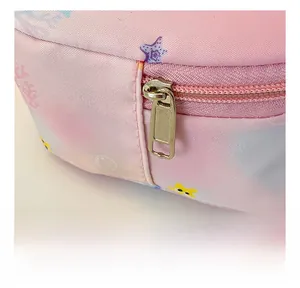 Close-up of smooth gold metal zipper and pink star pattern on a mini canvas bag