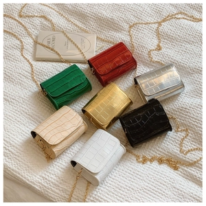 Flat lay of mini faux crocodile leather chain bags in seven vibrant fashion colors