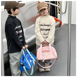 Détail de sacs oxford enfants rose et bleu avec bandoulières tissées dans le métro