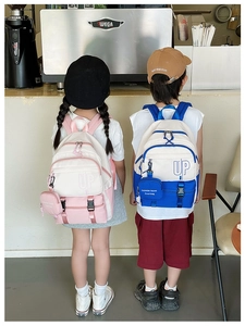Detail of pink and blue color-block kids backpacks with UP letter and mini coin purse