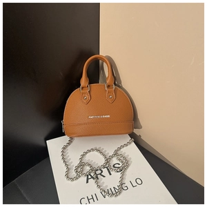 Detail of brown shell-shaped bag with lychee texture, top handle and silver ball chain