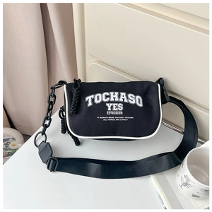 Detail of black canvas messenger bag featuring white letters and thick plastic chain