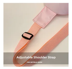 Detail showing adjustable pink canvas shoulder strap with a black plastic buckle