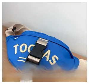 Close-up of the black plastic quick-release buckle on a blue canvas children chest bag