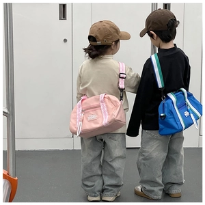 Détail de sacs bandoulière enfant rose et bleu avec sangles tissées et logo