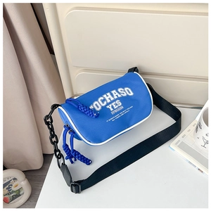 Detail of blue canvas crossbody bag with black thick chain and white printed letters
