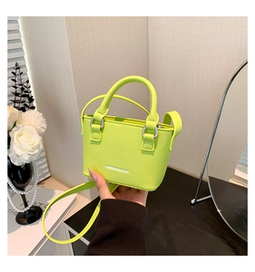 Close-up of a lime green mini bag with lychee texture and silver metal hardware details