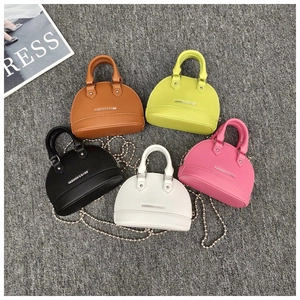 Flat lay of mini shell crossbody bags in five colors with lychee texture and chain straps