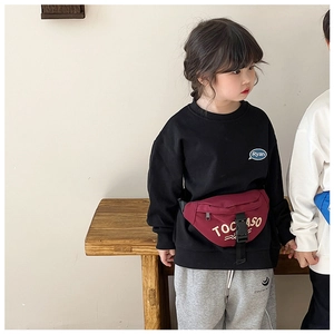 Detail of burgundy canvas kids chest bag with white letter print and black buckle