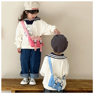 Kinder-Umhängetaschen in Rosa und Blau mit Doppelschnalle, präsentiert am Model