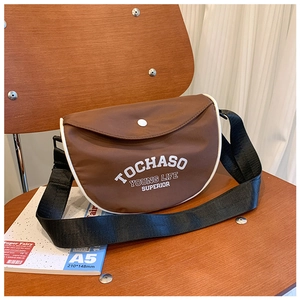 Gros plan d'un sac bandoulière enfant en nylon marron avec logo TOCHASO blanc imprimé