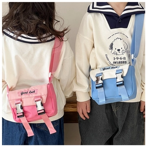 Detail von Kinder-Umhängetaschen in Pink und Blau mit Doppel-Schnallen und Glücks-Stickerei