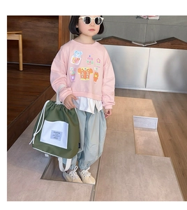Detail of pink cartoon sweatshirt with white drawstring backpack for kids school fashion