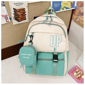 Detail of mint green and beige student backpack with mini coin purse and UP letters