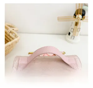 Detail of comfortable pink faux leather handles and soft fabric texture on kids backpack