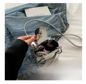 Mini sac bandoulière argenté effet miroir montrant l'espace intérieur pour maquillage