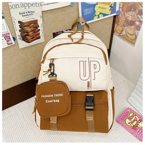 Detail of canvas school backpack featuring dual-tone ivory and brown design with buckle pocket