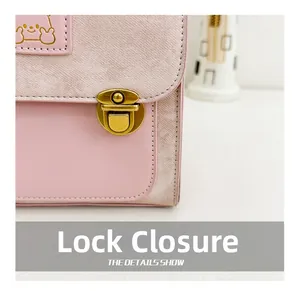 Detail of golden bear logo and secure metal buckle closure on pink leather kids backpack