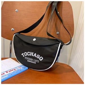 Détail du sac bandoulière semi-circulaire en nylon noir avec liseré blanc et logo