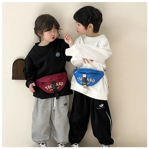 Detail of trendy canvas waist bags for kids in burgundy and blue with adjustable straps
