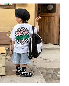 Close-up of a stylish black drawstring backpack with street art print for kids' fashion
