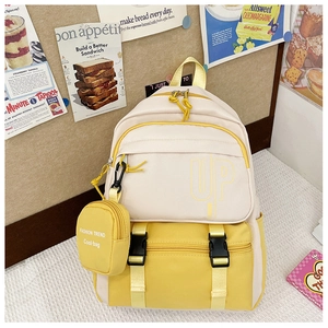 Detail of a yellow and off-white canvas kids backpack with pockets and hanging mini pouch
