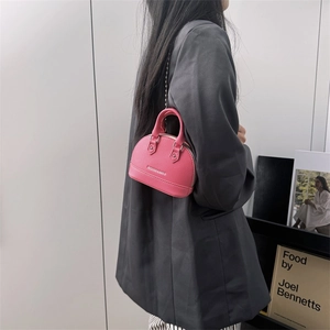 Mini pink shell shoulder bag in pebble leather with a silver chain and top handle