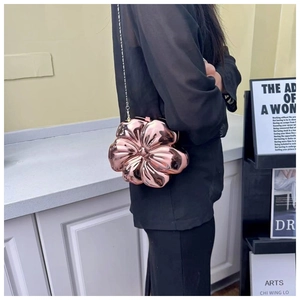 Detailed side view of a rose gold flower-shaped hard shell clutch bag with a metal chain strap