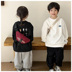 Detailed view of burgundy canvas chest bag with TOCASO print on stylish kids' sweatshirt
