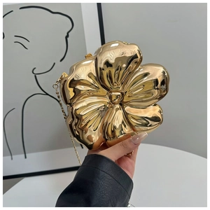 Detailed close-up of a gold petal-shaped handbag with a mirror finish and metal chain
