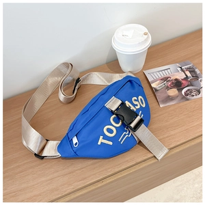 Detailed view of blue nylon kids chest bag with yellow 3D letter embroidery and beige strap