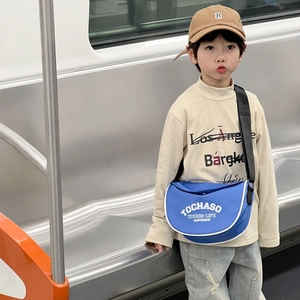 Sac bandoulière enfant en nylon bleu avec imprimé lettre dans un décor de métro
