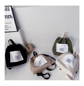Detail view of stylish drawstring backpacks in four colors with contrast pocket and text