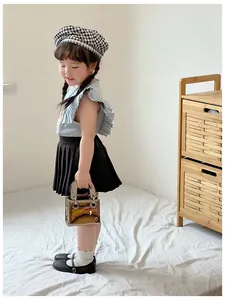 Détail du mini sac à main enfant en cuir verni argenté avec poignée métallique
