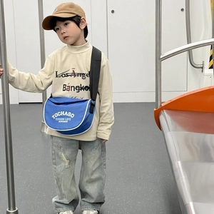Sac bandoulière bleu pour enfants avec lettres blanches et sangle réglable dans le métro