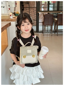 Kid wearing a vintage color-block bear backpack in a cozy cafe setting with soft lighting