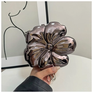 Macro detail of the chrome flower evening bag with a metallic mirror finish and bead chain