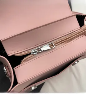 Detailed close-up of smooth silver zipper and pink faux leather on a mini backpack
