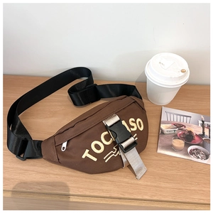 Detail of brown canvas kids chest bag with yellow TOCCASO embroidery and adjustable strap