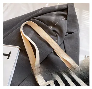 Detail of black and white striped canvas bag showing durable woven cotton handle straps