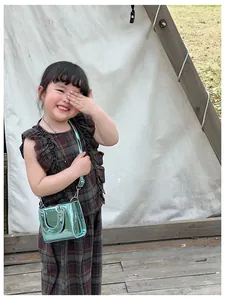 Détail du mini sac à bandoulière en cuir verni brillant sarcelle pour enfants et filles