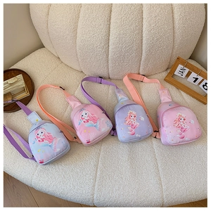 Detail view of four colorful cartoon mermaid canvas chest bags for kids on soft fabric