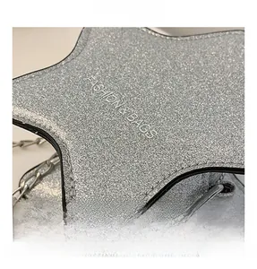 Détail macro du sac étoile pailleté argenté avec chaîne métal et gaufrage fashion