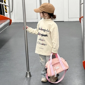 Sac bandoulière enfant en tissu Oxford et sweat beige à lettres dans un décor de métro